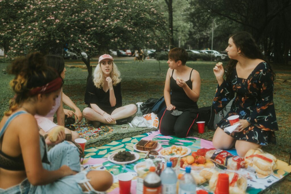 pexels-photo-11760997-11760997 A group of women enjoying a picnic at the park with food, drinks, and nature.