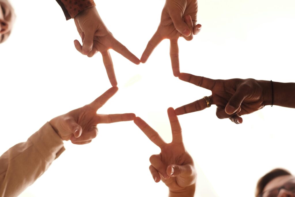 pexels-photo-6476771-6476771 A group of diverse hands forming a star shape, symbolizing unity and friendship.
